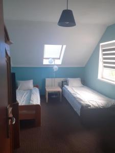a blue room with two beds and a window at Apartament 107 B, Noclegi pod dobrym Aniolem in Kudowa-Zdrój