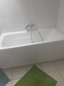 y baño con ducha y alfombra verde. en Apartament 107 B, Noclegi pod dobrym Aniolem, en Kudowa-Zdrój