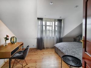 Schlafzimmer mit einem Bett, einem Schreibtisch und Stühlen in der Unterkunft Apartament IX Wieków CENTRUM PARKING VERY GOOD LOCATION TWO BEDROOMS 50 M2 in Kielce
