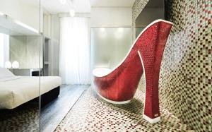a room with a red high heel shoe on a rug at Spagna Royal Suite in Rome