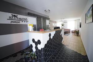 a lobby of a restaurant with a black and white wall at Szitakötő Panzió in Tiszafüred +26 photos