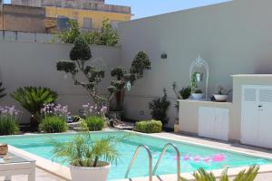 a swimming pool in a garden with plants at Appartamento da Ciuruzzo in Trapani