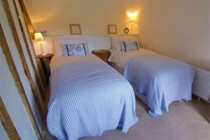 2 camas en una habitación de hotel con sábanas blancas en Three Pound Cottage, the Dartmoor Holiday Cottage en Lustleigh