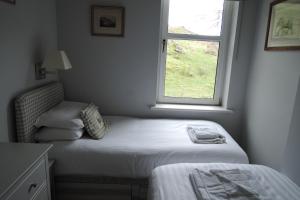 a small bedroom with a bed and a window at Tigh Beg Croft in Lerags