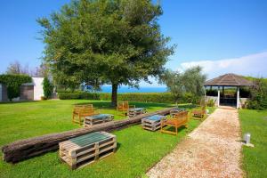 a group of chairs and tables in a yard with a tree at Casale del Mare in Castiglioncello