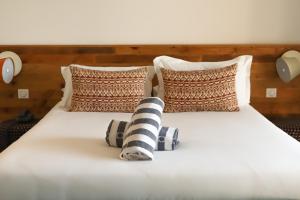 a bed with a white comforter and pillows at Le Balamina in Porto-Vecchio