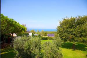 a view of a yard with trees and the ocean at Casale del Mare in Castiglioncello
