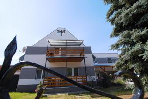 a building with a triangular roof with a staircase at Szitakötő Panzió in Tiszafüred