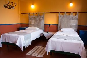 Habitación con 2 camas y sábanas blancas. en Hotel Votsala en Pyrgi Thermis