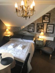 a bedroom with a large bed and a chandelier at Anchorage House in Whitby