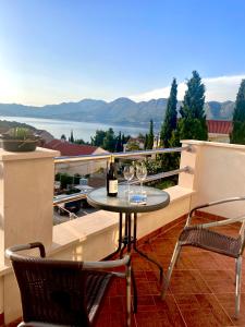 a balcony with a table and two glasses of wine at Apartments Miljas in Cavtat