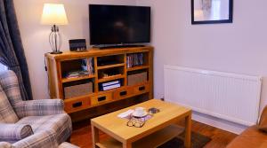 a living room with a tv and a coffee table at River Mist in Ironbridge