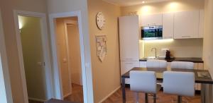 uma cozinha com uma mesa de jantar e cadeiras brancas em CIGNI HOUSE - da Anna&Ale em Basiglio
