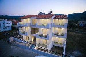 a white apartment building with lights on at Verano Apartments in Ayia anna