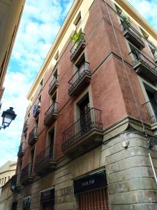 バルセロナにあるBYPILLOW Wanderの窓とバルコニー付きの高いレンガ造りの建物