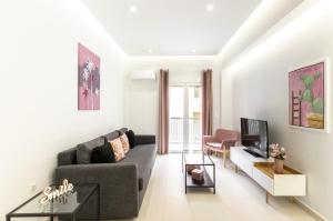 a living room with a couch and a tv at Omnia Pagrati Apartments in Athens