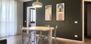 V12 Apartments - Trecate في Trecate: غرفة طعام مع طاولة بيضاء وكراسي