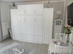 a large white cabinet in a room with a table at Seemannskiste in Grömitz