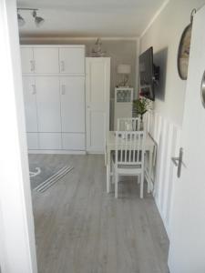 a living room with a table and white cabinets at Seemannskiste in Grömitz