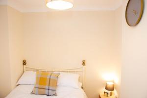 1 dormitorio con 1 cama y reloj en la pared en Romulus Court Fenham, en Elswick