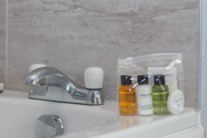 lavabo con grifo y botellas de jabón en Romulus Court Fenham en Elswick