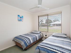 2 Betten in einem Schlafzimmer mit Fenster in der Unterkunft Happy Tails pet friendly air conditioned in Corlette