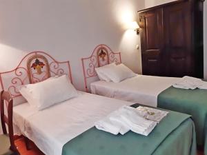 a room with two beds with white sheets at Horta do Muro in Campo Maior