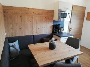 eine Küche mit einem Holztisch und einem Sofa sowie einem Tisch und Stühlen in der Unterkunft Appartements Spitaler in Ried im Zillertal