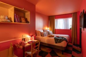 um pequeno quarto vermelho com uma cama e uma janela em PAUL & PIA - Welcome Home Hotel em Colmar