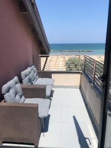 a balcony with chairs and a view of the beach at Hotel Melita in Rimini