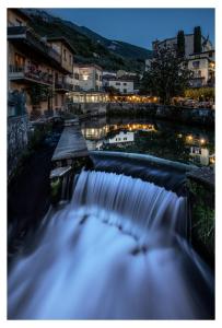 a waterfall in a city with buildings in the background at Hotel e Ristorante Cassone in Malcesine