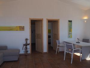 a living room with a table and chairs and a couch at Stazzu Giasti Agriturismo in Aglientu