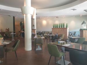 a restaurant with tables and chairs in a room at Fletcher Strandhotel Renesse in Renesse