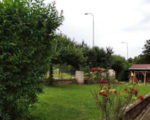 a garden with red flowers and a gazebo at Motel Grádo in Prague