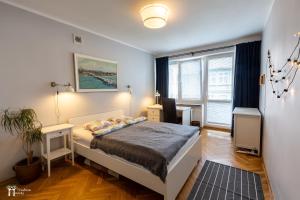 um quarto com uma cama e uma grande janela em White Pier Apartament em Sopot