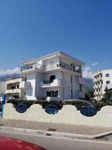 un bâtiment blanc avec des chaises bleues devant lui dans l'établissement Hotel Tirreno Formia, à Formia