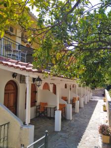 a courtyard of a building with tables and chairs at Ηotel Della in Parga