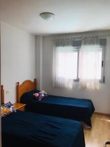 - une chambre avec 2 lits et une fenêtre dans l'établissement Apartamento en la playa de Gandia, à Gandía