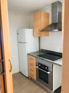 Il comprend une petite cuisine équipée d'un réfrigérateur et d'une cuisinière. dans l'établissement Apartamento en la playa de Gandia, à Gandía