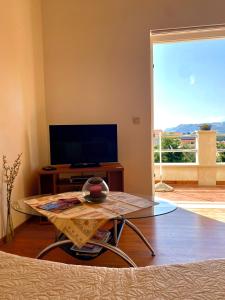 a living room with a table and a tv at Apartments Miljas in Cavtat