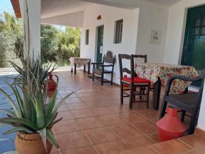 een veranda met stoelen en tafels en een potplant bij Horta do Muro in Campo Maior