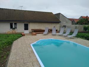 a swimming pool with chairs and a table at Apartmány Zaječák in Zaječí