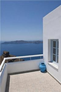 a white balcony with a view of the water at Casa Florina in Imerovigli