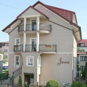 a white building with balconies on the side of it at Pokoje Gościnne Jana in Łeba