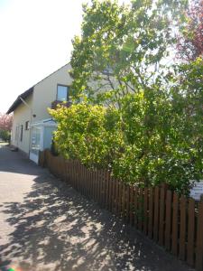 a fence in front of a house with trees at Seemannskiste in Grömitz