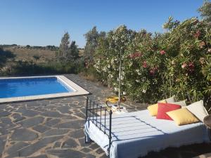 a couch sitting next to a swimming pool at Horta do Muro in Campo Maior