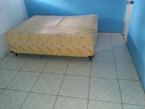 a bed sitting on a tiled floor in a room at CASA das ORQUÍDEAS NOTA 1000 in Teresina