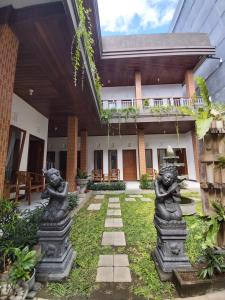 an external view of a house with a garden with statues at Genta House in Kuta