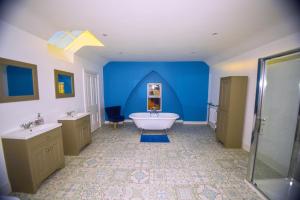 a bathroom with a tub and a blue wall at Pantycelyn in Caernarfon +21 photos