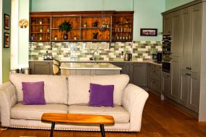 a living room with a couch and a kitchen at Pantycelyn in Caernarfon